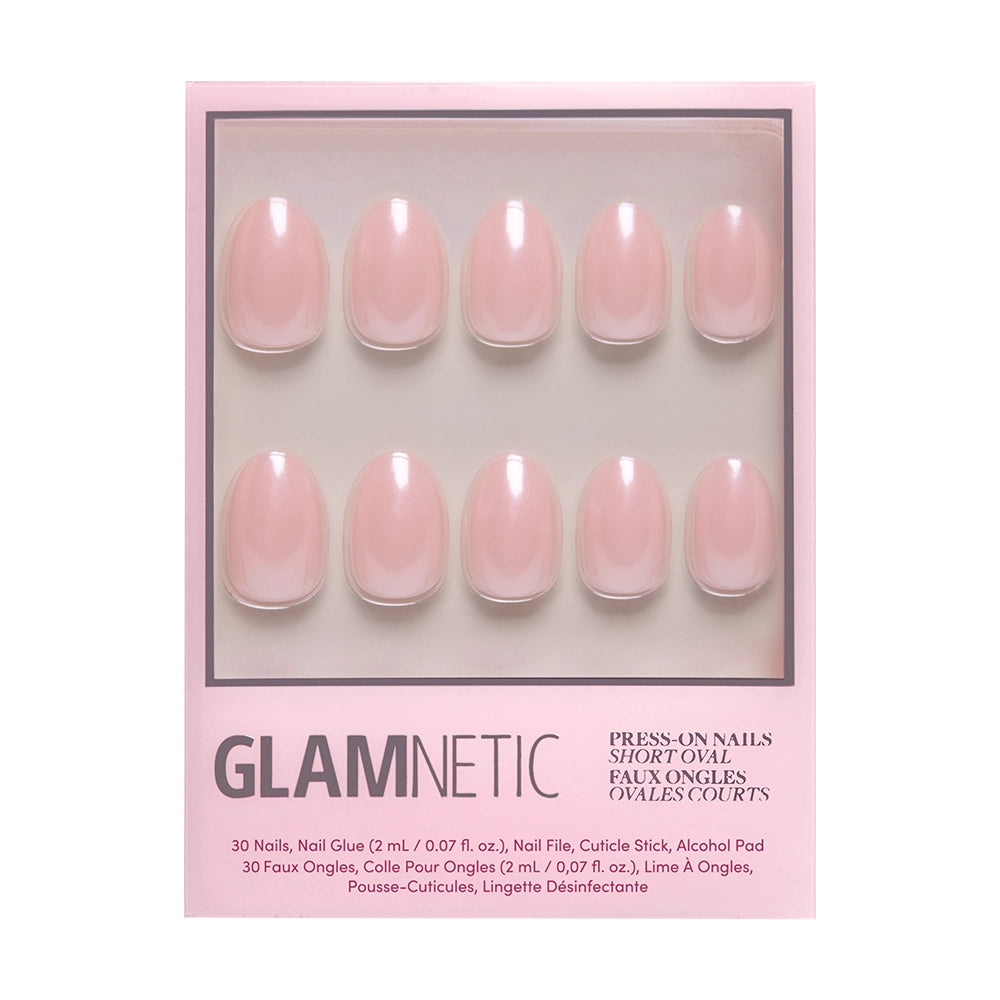 A box of glamnetic Pinch Me press-on nails in short oval shape, featuring ten glossy glazed light pink faux nails, arranged in two rows and displayed in pink packaging.